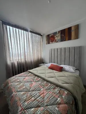 a bedroom with a bed with a blanket and a window at Apartamento en Santa Beatriz in Lima
