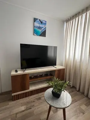 a living room with a flat screen tv on a entertainment center at Apartamento en Santa Beatriz in Lima
