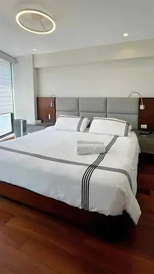 a bedroom with a large bed with white sheets at Luxury apartment in Miraflores near Larcomar in Lima