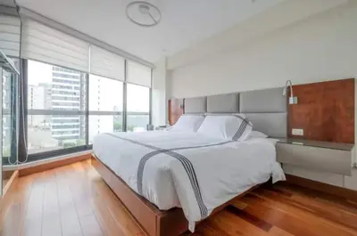 a white bedroom with a large bed and large windows at Luxury apartment in Miraflores near Larcomar in Lima