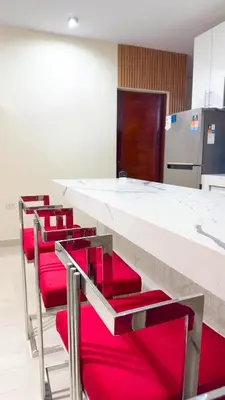 a row of red chairs at a counter in a kitchen at Lovely Apartment-Punta Hermosa in Punta Hermosa