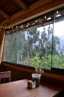 a table in a room with a large window at Cabaña rodeada de naturaleza en Ollantaytambo in Ollantaytambo