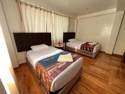 a small bedroom with two beds and a window at Tikary Lodge in Cusco