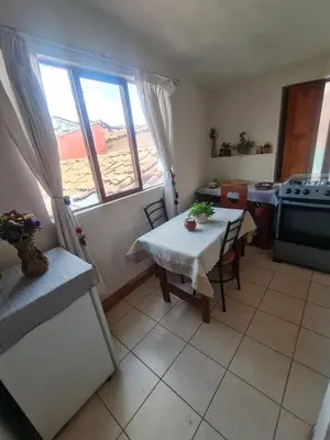 a room with a table and a kitchen with a window at Minidepartamento amoblado in Cusco