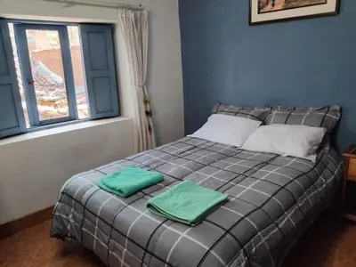 a bedroom with a bed with two green towels on it at Minidepartamento amoblado in Cusco