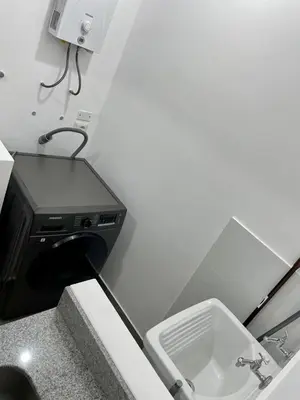 a small bathroom with a sink and a microwave at Depa en Av Javier Prado frente a San isi in Lima