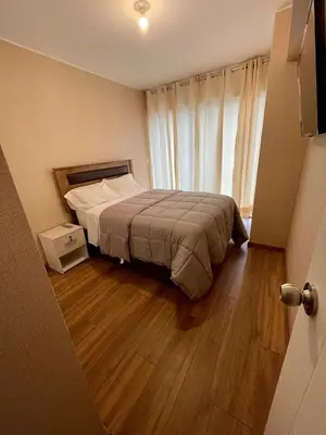 a bedroom with a bed and a wooden floor at Depa en Av Javier Prado frente a San isi in Lima