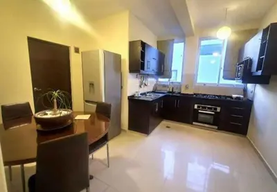 a large kitchen with a wooden table and a dining room at chaski apart in Cusco