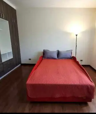 a bedroom with a red bed in a room at chaski apart in Cusco