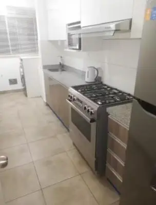 a kitchen with a stove and a counter top at Varela Piso 12 in Lima