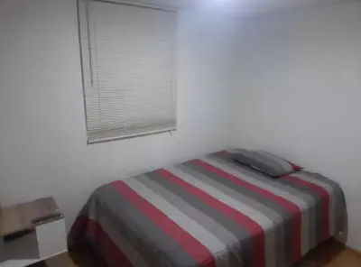 a bedroom with a bed with a striped blanket and a window at Varela Piso 12 in Lima