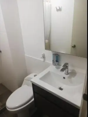 a bathroom with a white toilet and a sink at Varela Piso 12 in Lima