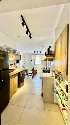 a large kitchen with wooden cabinets and a dining room at Apartamentos Boho in Punta Hermosa