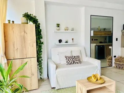 a living room with a white chair and a table at Apartamentos Boho in Punta Hermosa