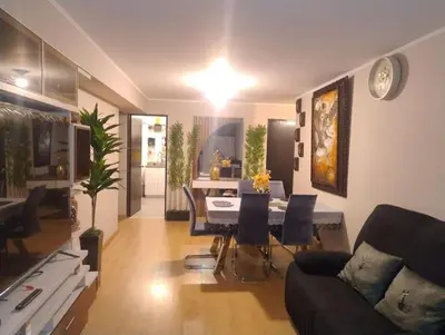 a living room with a couch and a table with chairs at Depa con estacionamiento 3 dorm en Av Brasil in Lima
