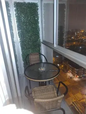 a table and chairs on a balcony with a view of a city at Depa con estacionamiento 3 dorm en Av Brasil in Lima