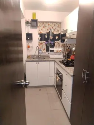 a kitchen with white cabinets and a sink and a stove at Depa con estacionamiento 3 dorm en Av Brasil in Lima