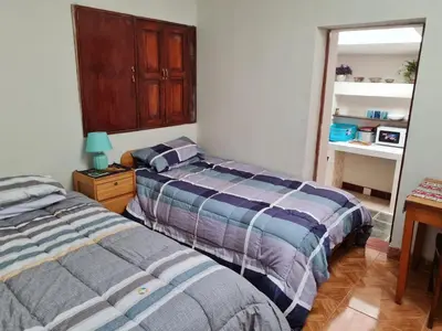 a bedroom with two beds and a mirror at Mini departamento 2 camas en el centro in Cusco