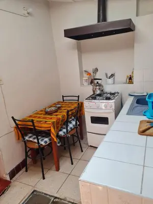 a kitchen with a table with chairs and a stove at Mini departamento 2 camas en el centro in Cusco