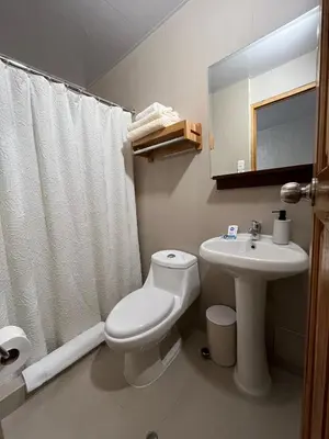 a bathroom with a white toilet and a sink at Casa Terra Cusco in Cusco
