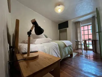 a bedroom with a bed and a lamp on a table at Casa Terra Cusco in Cusco