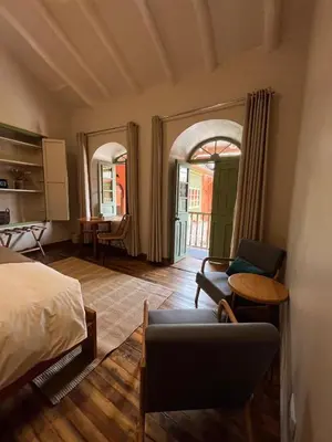 a bedroom with a bed and a chair and a table at Casa Terra Cusco in Cusco