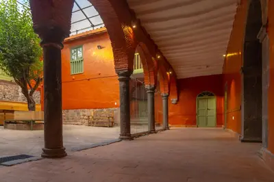 an arcade in a building with a green door at Casa Terra Cusco in Cusco