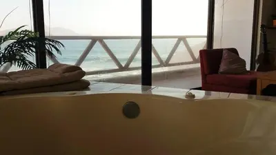 a bath tub in a room with a view of the ocean at Casa 4 DORM - 3 VISTAMAR, 14 a 20 pax piscina propia in San Bartolo