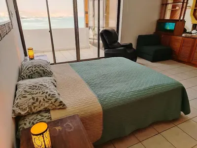 a bedroom with a bed with a chair and a window at Casa 4 DORM - 3 VISTAMAR, 14 a 20 pax piscina propia in San Bartolo