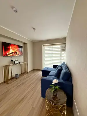 a living room with a blue couch and a table at Lima Central Apartment in Lima