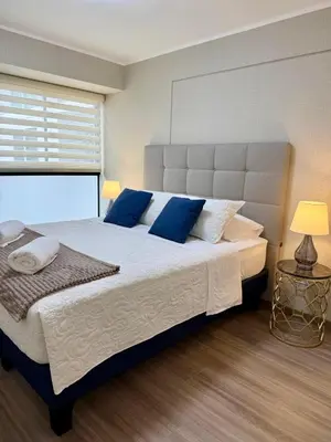 a bedroom with a large bed with blue pillows at Lima Central Apartment in Lima