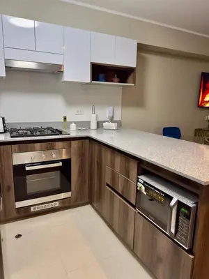 a kitchen with wooden cabinets and a counter top at Lima Central Apartment in Lima