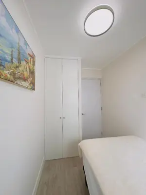 a white bedroom with a bed and a painting at APPARTEMENT CHIC MIRAFLORES Paradis in Lima