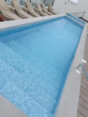 a swimming pool with blue water and chairs at APPARTEMENT CHIC MIRAFLORES Paradis in Lima