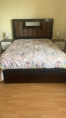 a bed in a bedroom with two night stands and two lamps at Quiet room in Lima