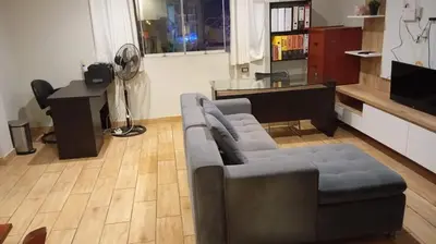 a living room with a couch and a desk at Quiet room in Lima