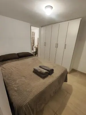 a bedroom with a bed with two towels on it at Habitación independiente con terraza y cocina in Lima