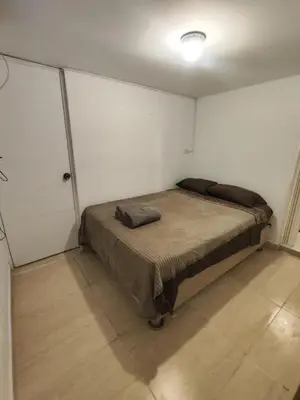 a bedroom with a bed in a white room at Habitación independiente con terraza y cocina in Lima