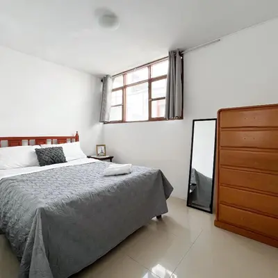 a bedroom with a bed and a dresser and a mirror at Direct Beach Access Apt & Speedy WiFi in Punta Hermosa