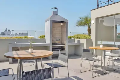 a patio with two tables and chairs and a grill at Apartment in the most touristy area of Miraflores in Lima