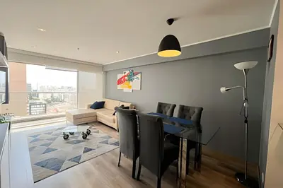 a living room with a table and a couch at Apartment in the most touristy area of Miraflores in Lima