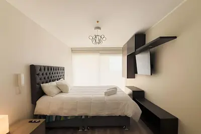 a bedroom with a bed with a black headboard at Apartment in the most touristy area of Miraflores in Lima