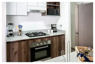 a kitchen with a stove top oven next to a refrigerator at Fantastic New Apartment with Rooftop Pool and Gym in San Isidro in Lima