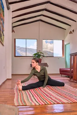 a woman sitting on a rug on the floor at Piedra Wasi Ecolodge Urubamba in Urubamba
