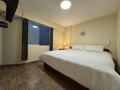 a bedroom with a large bed and a window at Style and location in Miraflores by AG in Lima