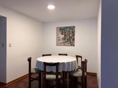 a dining room with a white table and chairs at Villaflores Apartments in Lima