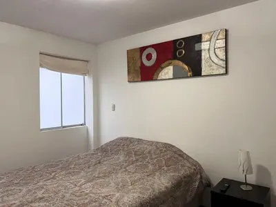 a bedroom with a bed and a picture on the wall at Villaflores Apartments in Lima
