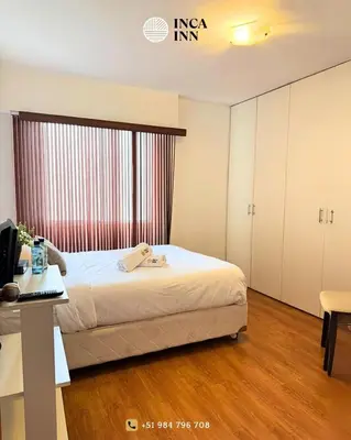 a bedroom with a bed and a desk with a computer at Miraflores ocean view in Lima