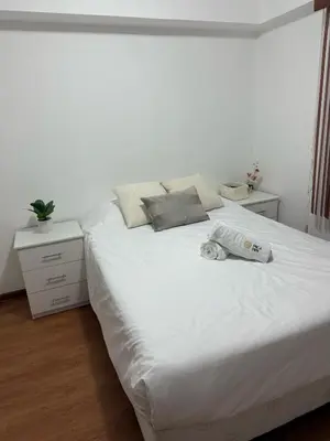 a bedroom with a white bed with a bag on it at Miraflores ocean view in Lima