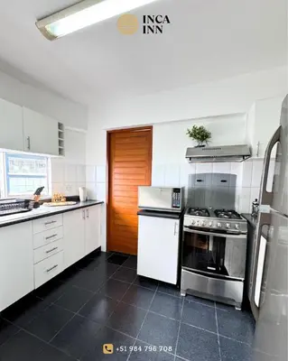 a kitchen with white cabinets and a stove top oven at Miraflores ocean view in Lima